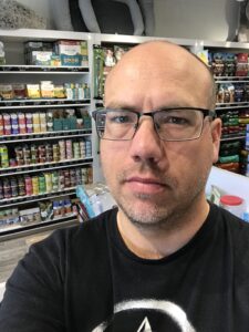 A photo of Kris, the store owner of Bone & Biscuit Magrath, a pet store in Edmonton, Alberta, inside the store. 