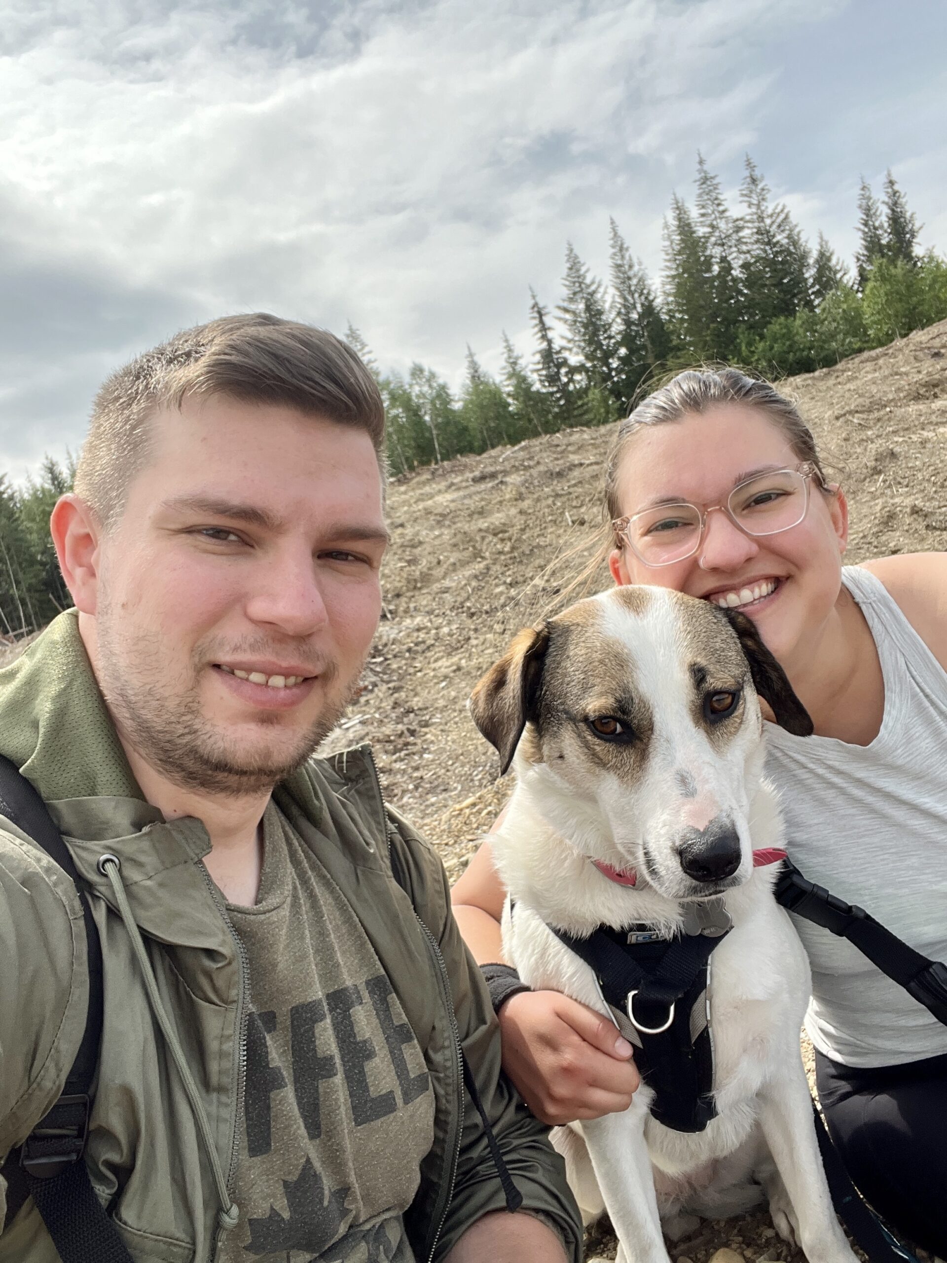 A photo of the Bone & Biscuit Garneau family, which includes Courtney the owner, Kale her partner and Ellie their dog while standing outdoors in Edmonton Alberta
