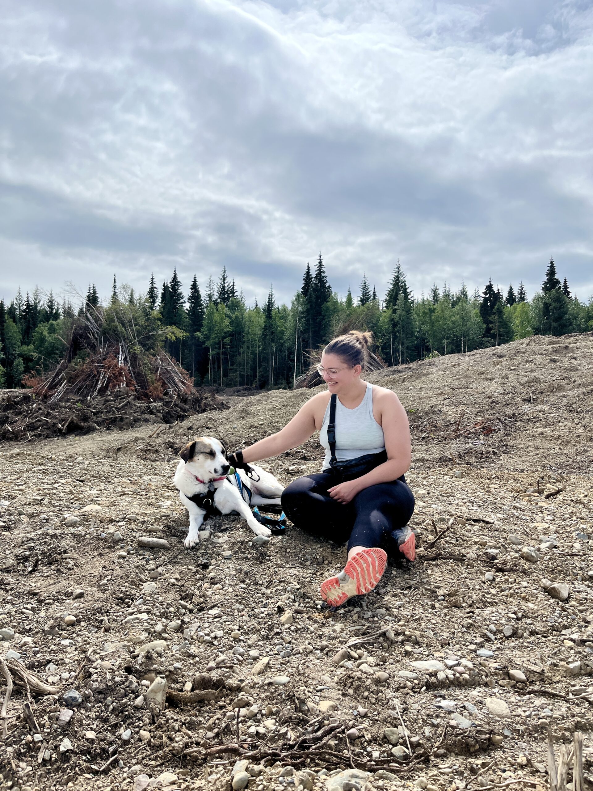 Courtney, the owner of the new Bone & Biscuit Garneau, sits on the ground with her dog, Ellie, while outdoors in Edmonton Alberta.