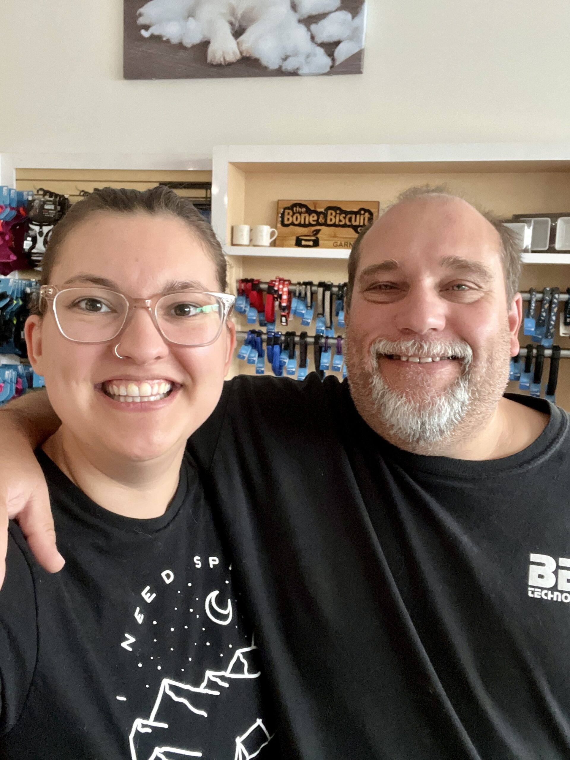 The store owner of the new Bone & Biscuit Garneau, Courtney, stands smiling and hugging her dad who is also her business partner while inside the Bone & Biscuit Garneau store in Edmonton, Alberta.