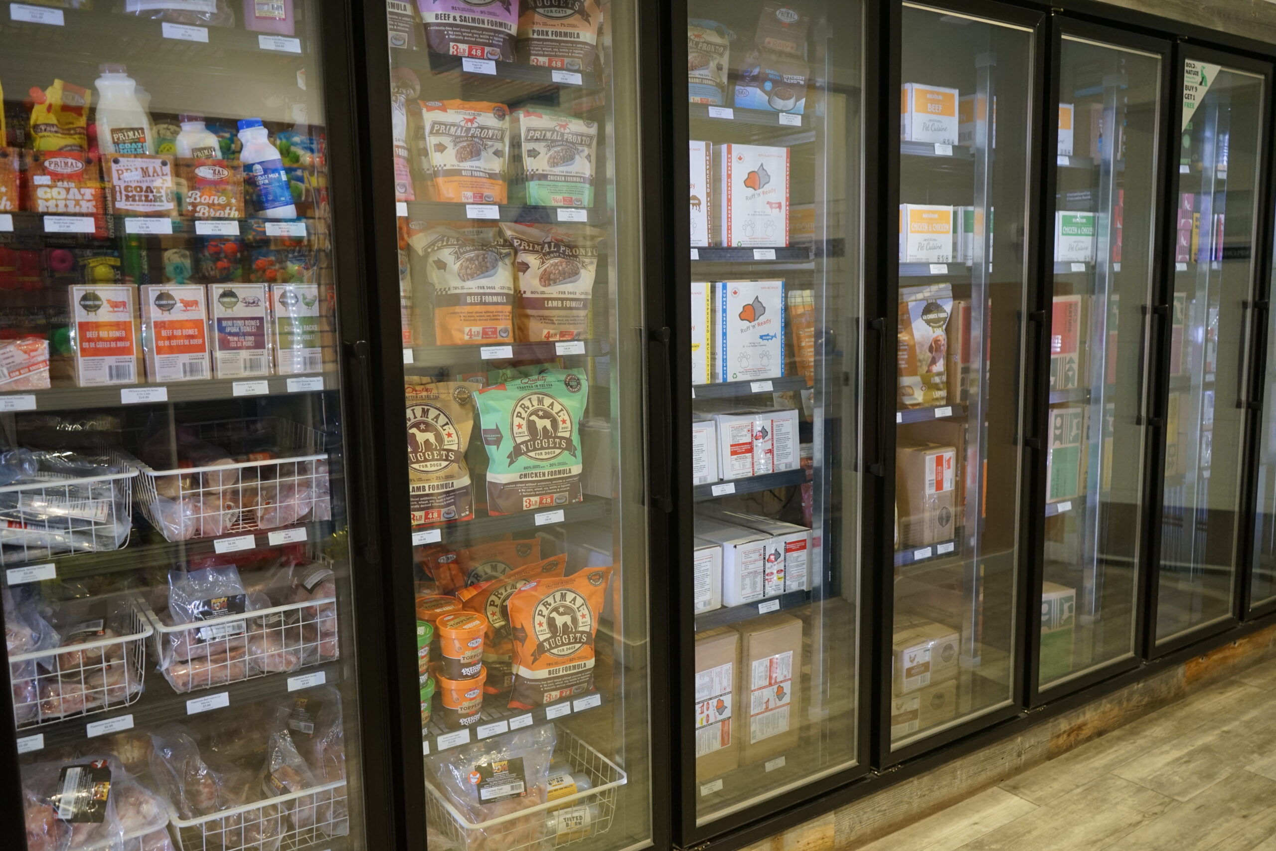 The freezer and fridge display cases of pet food and raw food at Bone & Biscuit Okotoks, a pet supply store in Okotoks Alberta with new owners.