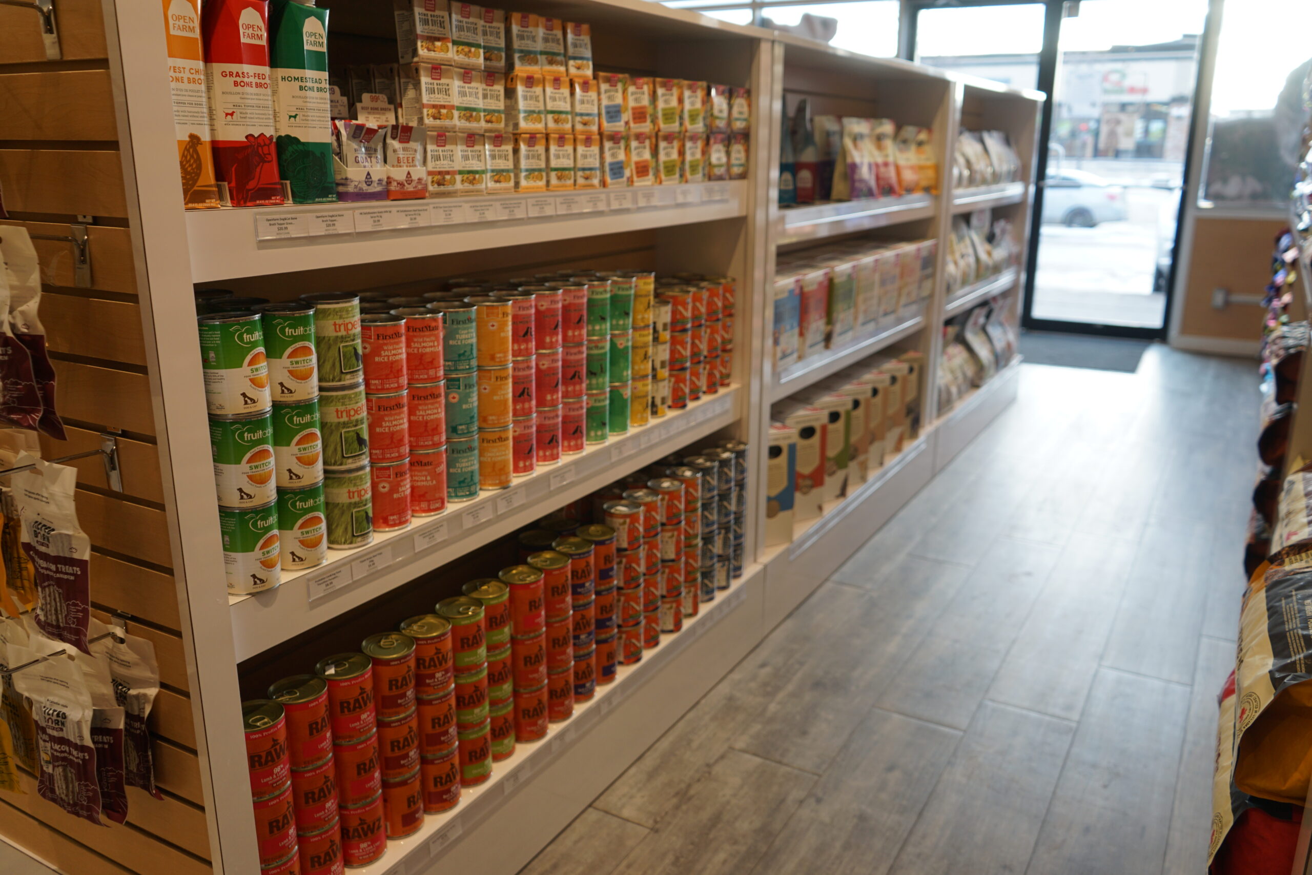 The canned food display shelfs of pet food at Bone & Biscuit Okotoks, a pet supply store in Okotoks Alberta with new owners.